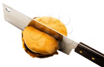 Butcher knife cutting a burger isolated over white