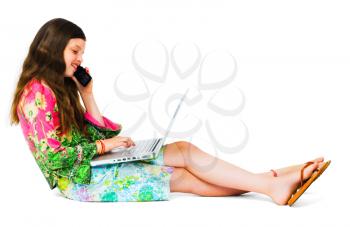 Happy girl using a laptop and a mobile isolated over white