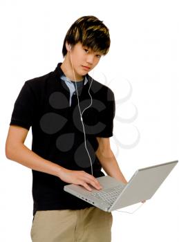 Asian teenage boy using a laptop and posing isolated over white