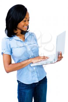 Latin American woman using a laptop and smiling isolated over white