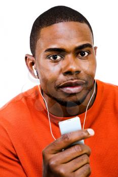 Mixedrace man listening to music on a MP3 player isolated over white