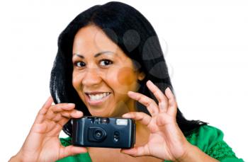 Portrait of a woman photographing with a camera and smiling isolated over white