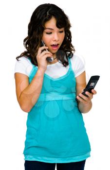 Shocked teenage girl using mobile phones isolated over white