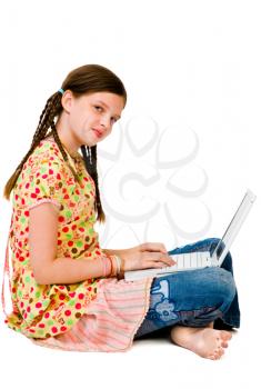 Confident girl using a laptop and smiling isolated over white