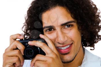 Portrait of a man photographing with a camera and smiling isolated over white