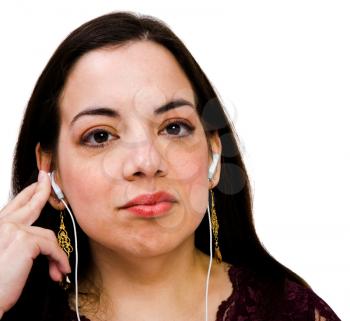 Mixedrace woman listening to music on a MP3 player isolated over white
