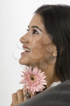 Close-up of a woman smiling and holding a flower