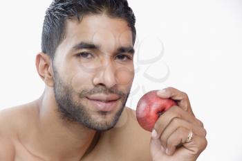Portrait of a macho man eating apple