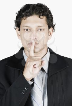 Businessman with his fingers on his lips