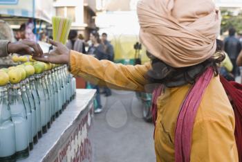 Street vendor giving alms to a beggar, New Delhi, India