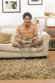 Young man playing video game in the living room