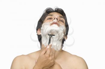 Young man shaving his face