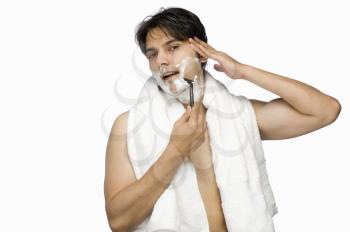 Young man shaving his face