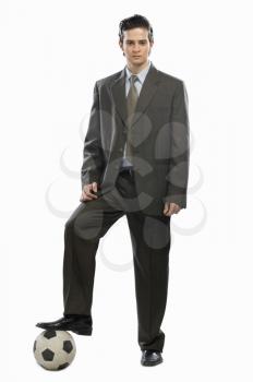 Portrait of a businessman with his foot on a soccer ball