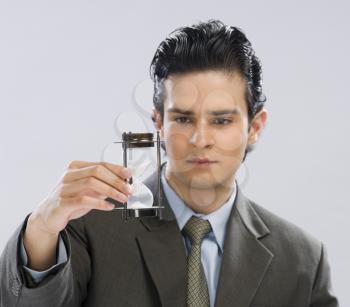 Businessman looking at an hourglass