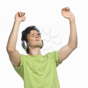 Man listening to music with his hands raised