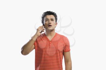 Man talking on a mobile phone and looking shocked