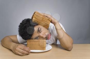 Man looking sad and putting his head between the slices of bread