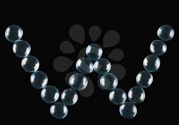 Close-up of marble balls arranged in the shape of letter W