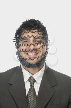 Portrait of a businessman smiling wrapped with telephone cord