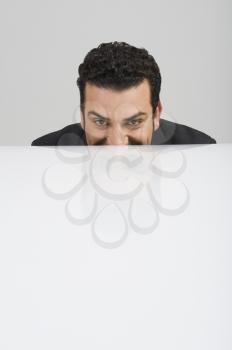 Businessman peeking over a desk