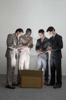 Businessmen applauding over an illuminated cardboard box
