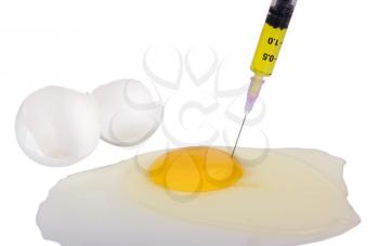 Syringe injecting yellow liquid in egg yolk