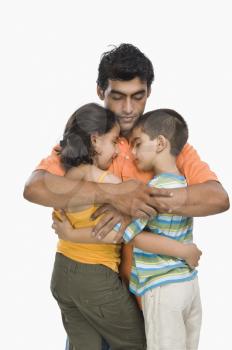 Close-up of a man hugging his children