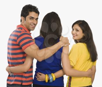 Rear view of three friends standing and smiling