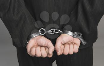Rear view of a businessman tied up with handcuffs