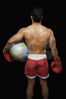 Rear view of a male boxer holding a globe