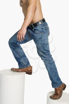 Man in jeans climbing up steps