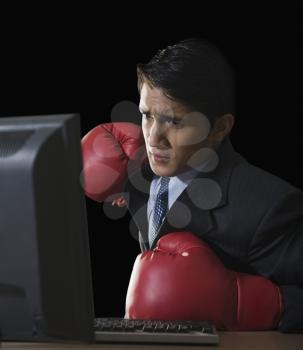 Businessman punching a desktop pc