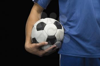 Mid section view of a soccer player with a soccer ball