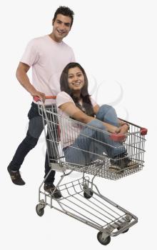 Man pushing a woman sitting in shopping cart