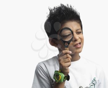 Boy holding a magnifying glass in front of his eye