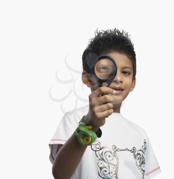 Portrait of a boy looking through a magnifying glass