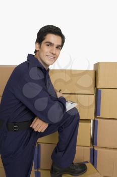 Portrait of a store incharge standing near cardboard boxes and smiling