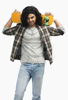 Man holding a skateboard on his shoulders
