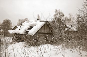 old wooden house amongst winter snow