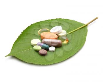 vitamins, tablets and pills on green leaf