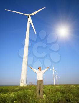 man and wind turbines under blue sky