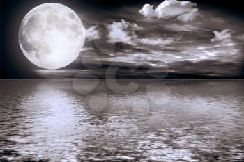 The full moon in clouds reflected in water