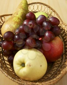 Fresh fruits in basket on table