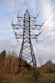 Large pole with power line wires near the forest