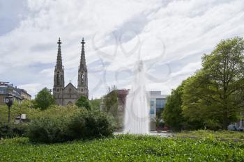 Beautiful green park with a fountain, next to the Evangelical Church in Europe