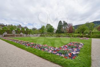 Lawn with flowers of daisies and tulips in a European park in the city of Baden Baden