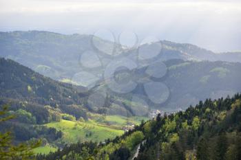 Picturesque landscape in the mountains of the Schwarzwald, with a valley, villages, a mixed forest and rays of sunlight. Germany nature