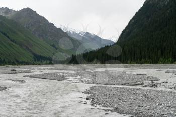 River and mountains with white clouds. Shot in Xinjiang, China.