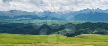 Grassland and mountains in a cloudy day. Shot in Xinjiang, China.
